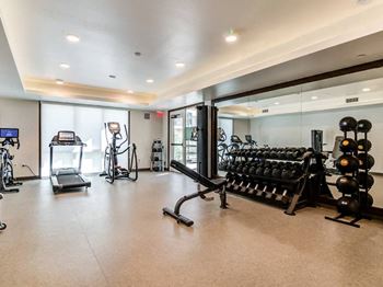 A spacious gym with a variety of equipment including treadmills, exercise bikes, and weight racks.
